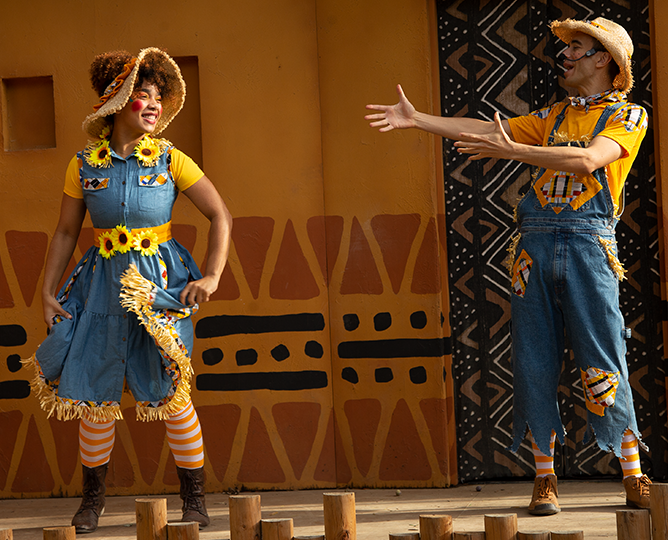 two performers dressed as scarecrows on stage