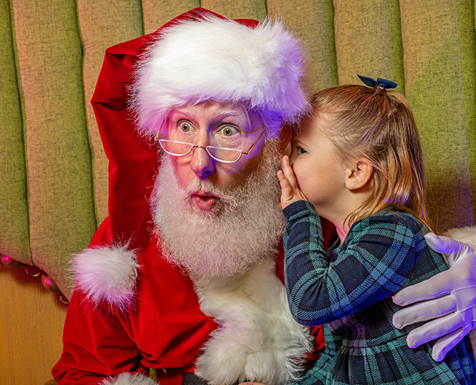 Santa with a child whispering in his ear