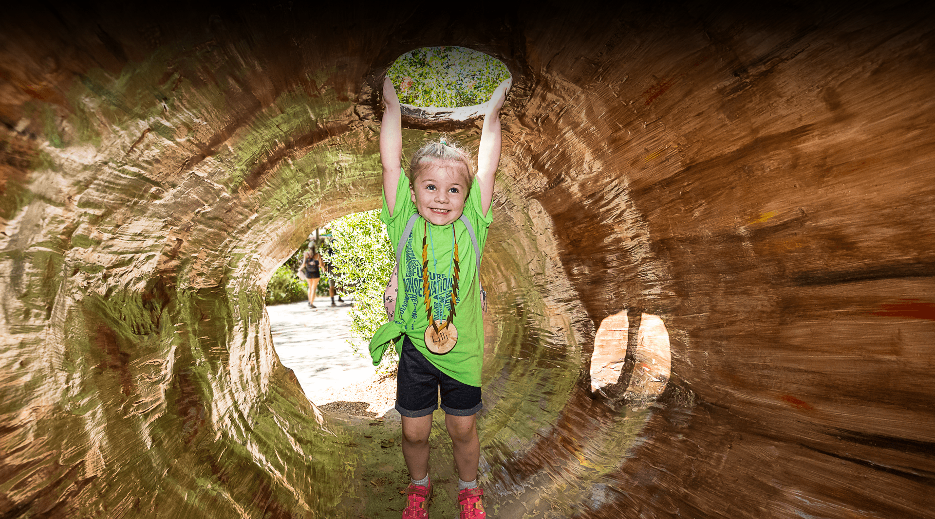 child playing in a log